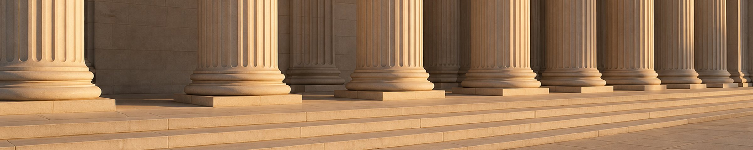 A classical stone portico with fluted columns and steps in warm light.